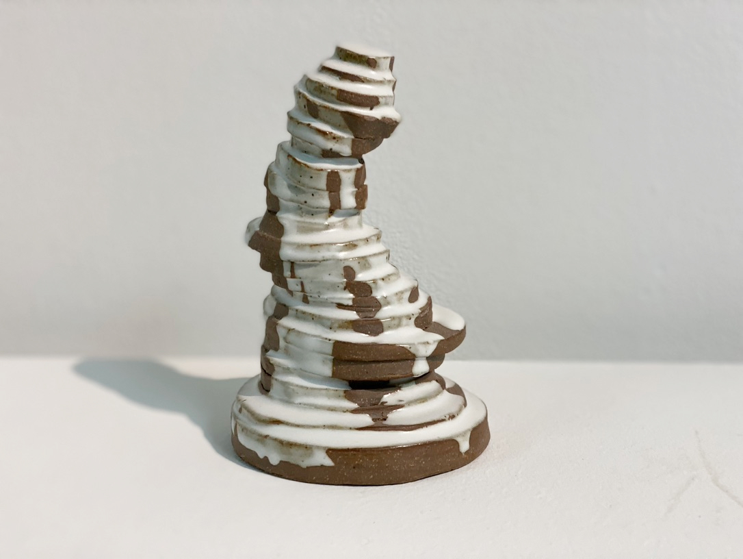 Ceramic stacked disks with white glaze dripping down.